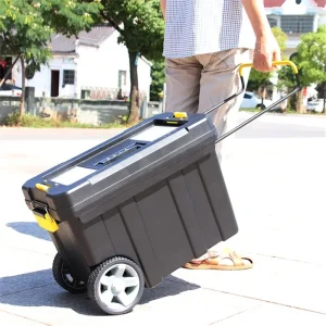 Portable tool chest being wheeled along a sidewalk by a person in casual attire